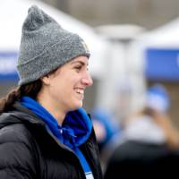 An alum smiles wearing a winter hat at the tailgate
